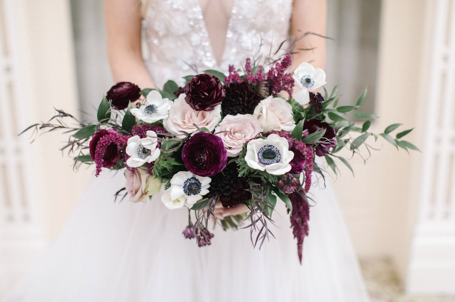 Burgundy anemones and scabiosa in bridal bouquet for winter wedding. 